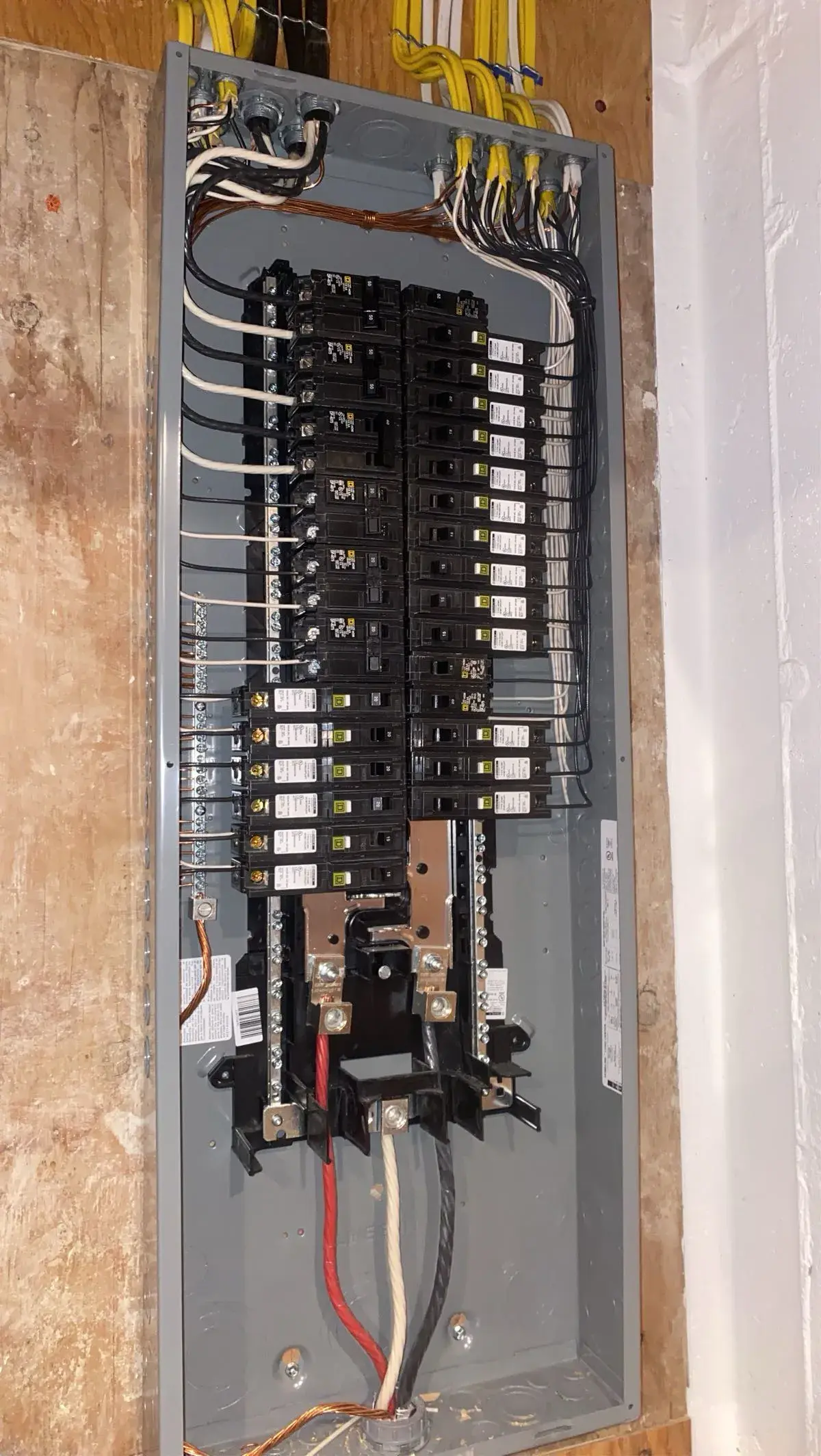 Open residential electrical panel with neatly landed branch circuits during service work